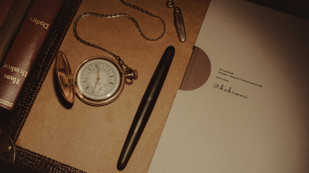 fountain pens arranged on vintage desk with writing accessories